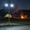 Camping scene at night with a portable light stand illuminating the area.